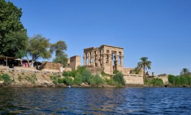 a large building sitting on top of a cliff next to a body of water