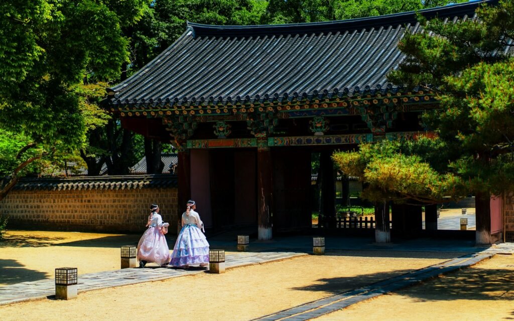 a couple of women walking down a street next to a building