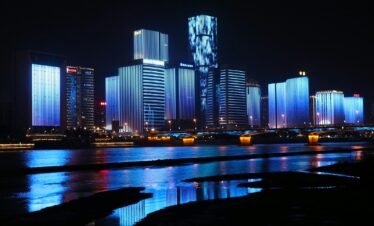 photography of lighted buildings reflecting on water